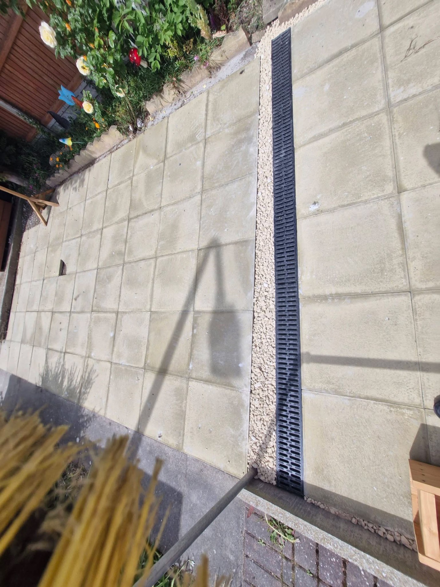 Close-up of concrete slab path with drainage channel and pebble trim