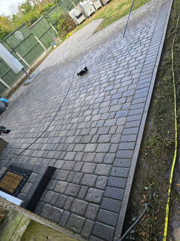 New charcoal block-paved patio freshly installed in a rear garden