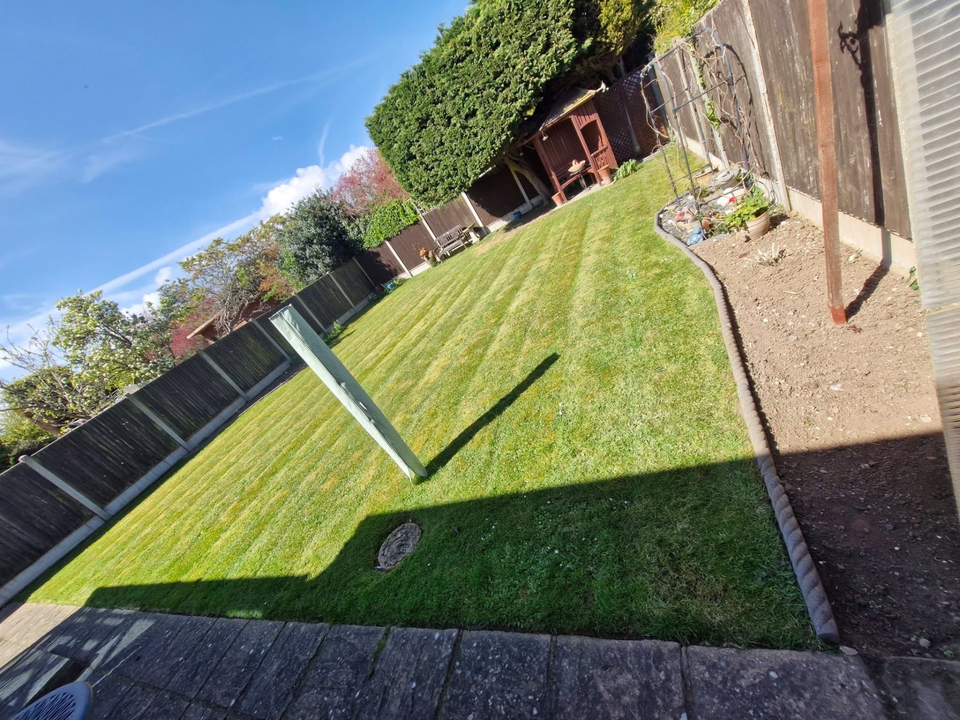 Rear lawn cut to a striped finish with cleared border