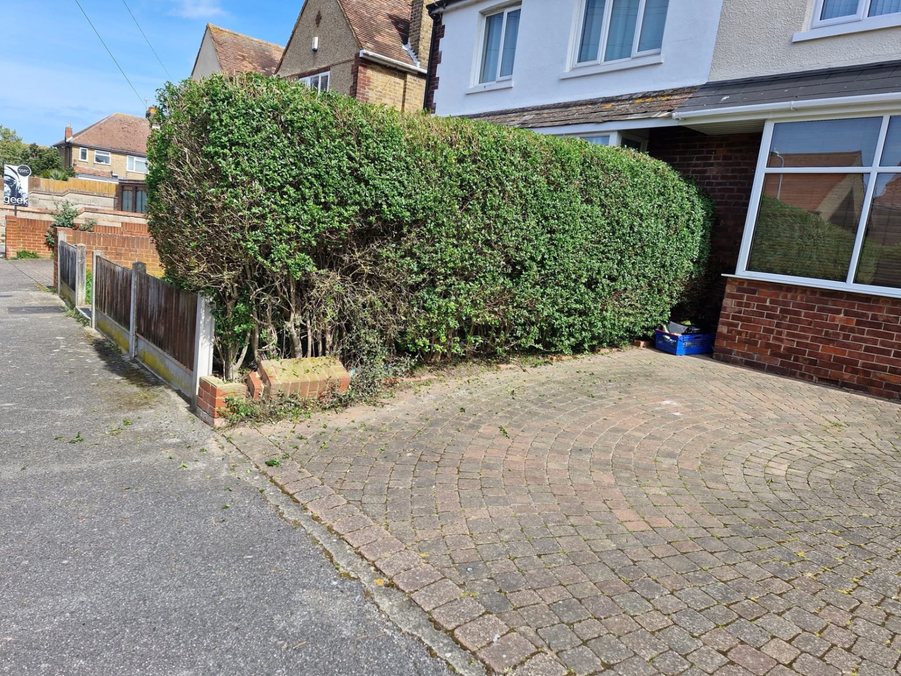 Front boundary hedge trimmed neatly along block-paved driveway