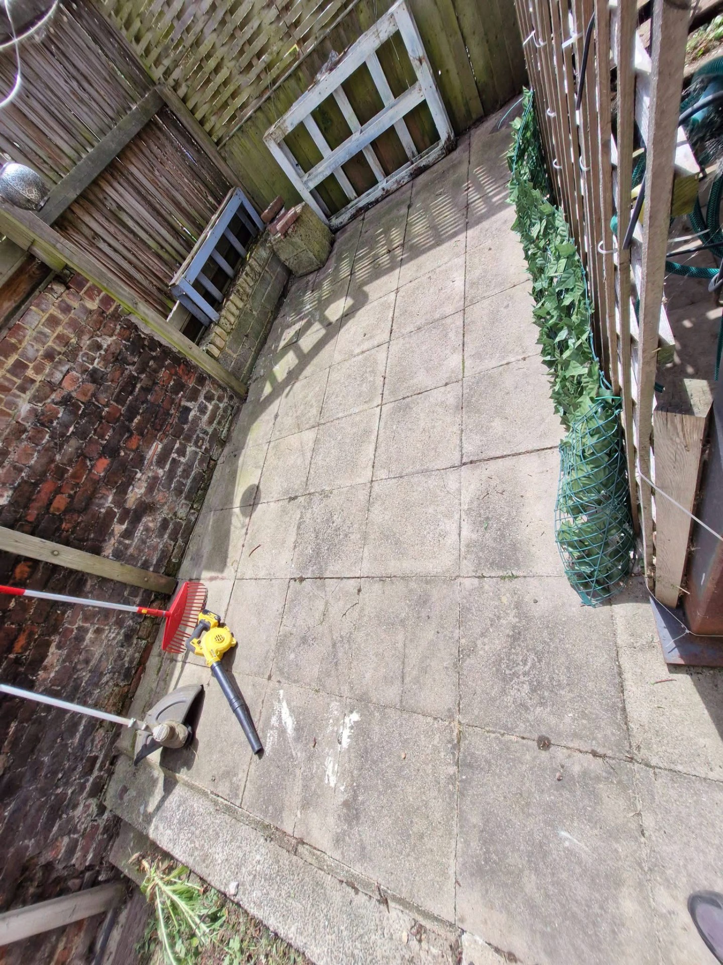 Yard patio jet-washed and tidied with tools laid out