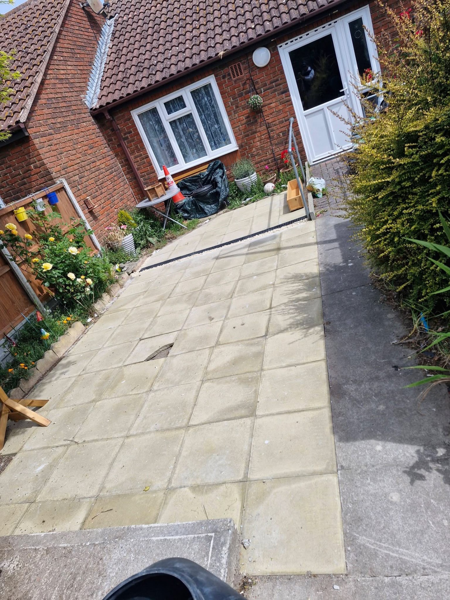 Newly laid concrete slab side path leading to bungalow entrance