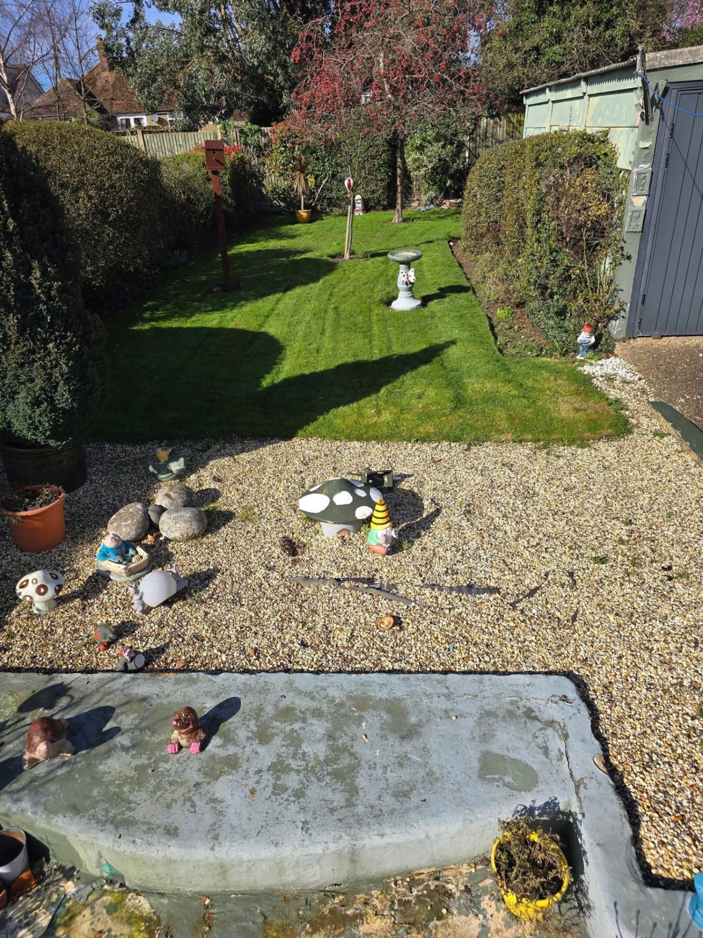 Garden lawn cut with tidy gravel border and ornamental features