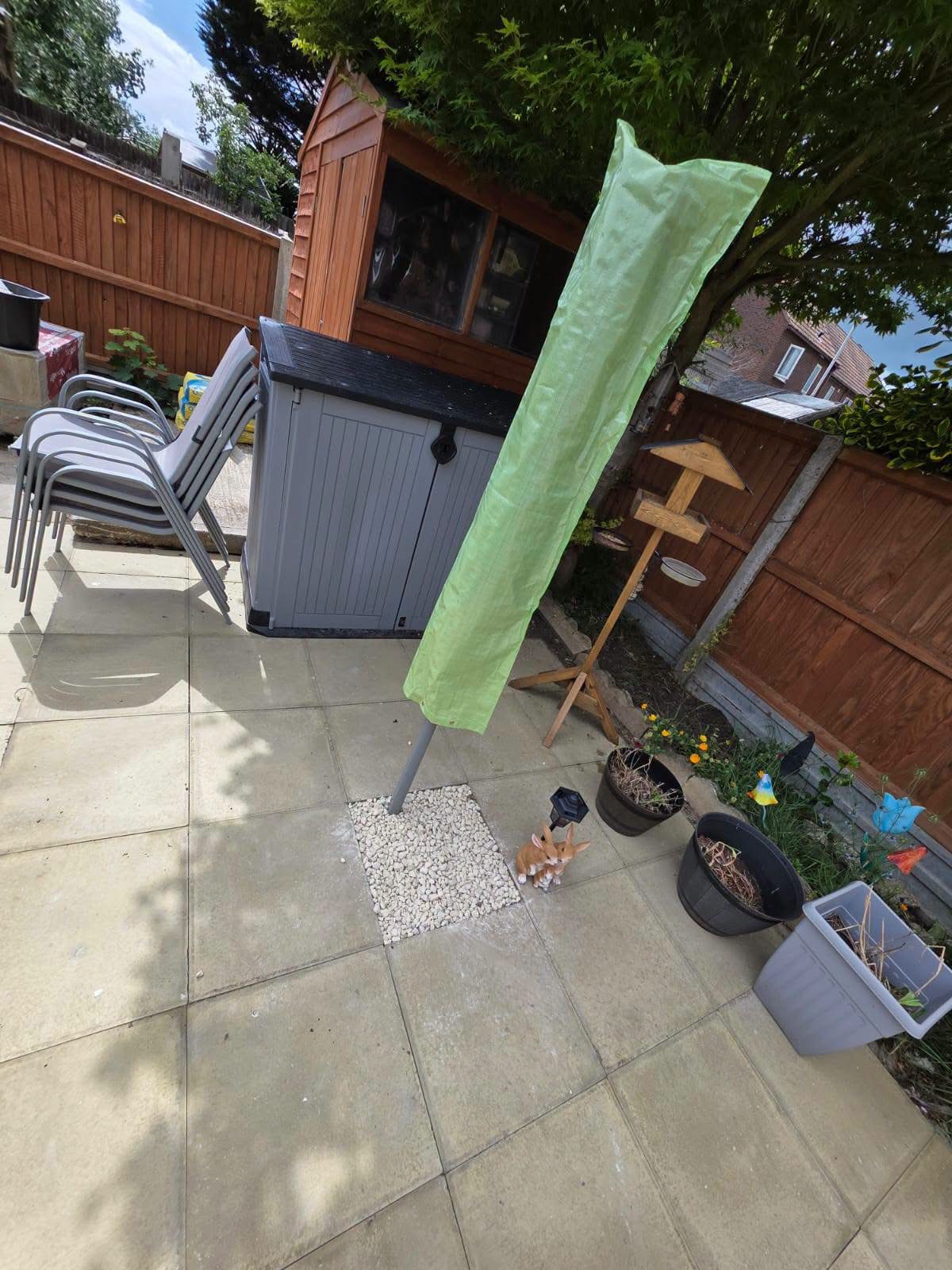 Rear patio with garden storage box, chairs, parasol and shed