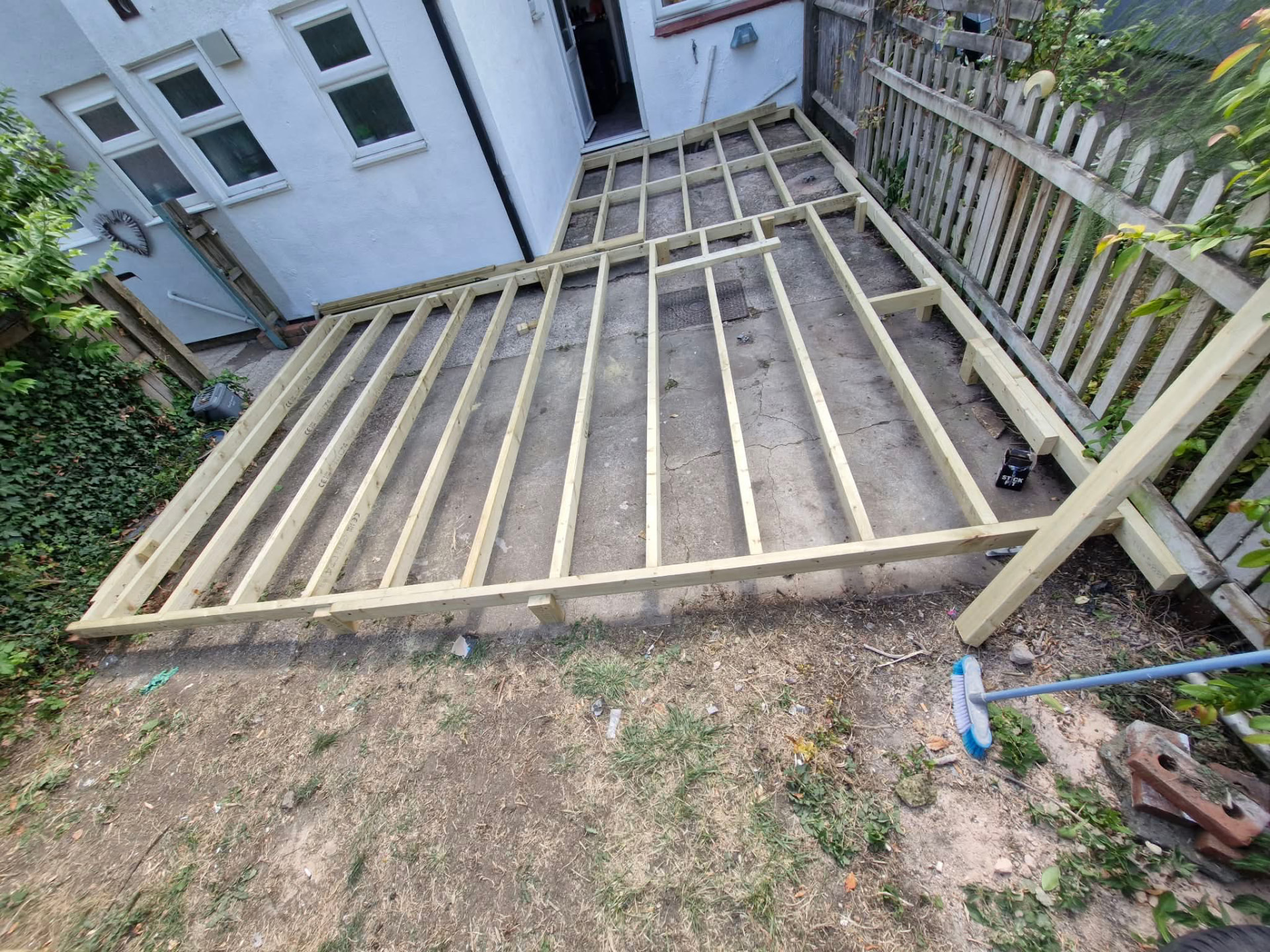 Full decking sub-frame of treated joists levelled across a rear garden