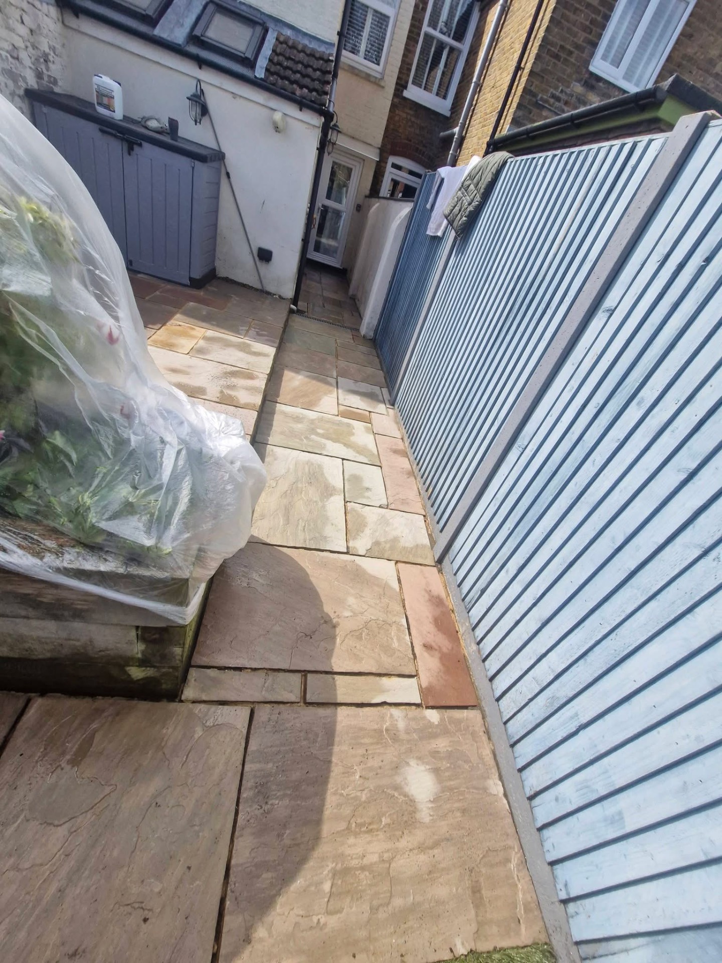 Indian sandstone side path swept and cleared alongside garden waste bags