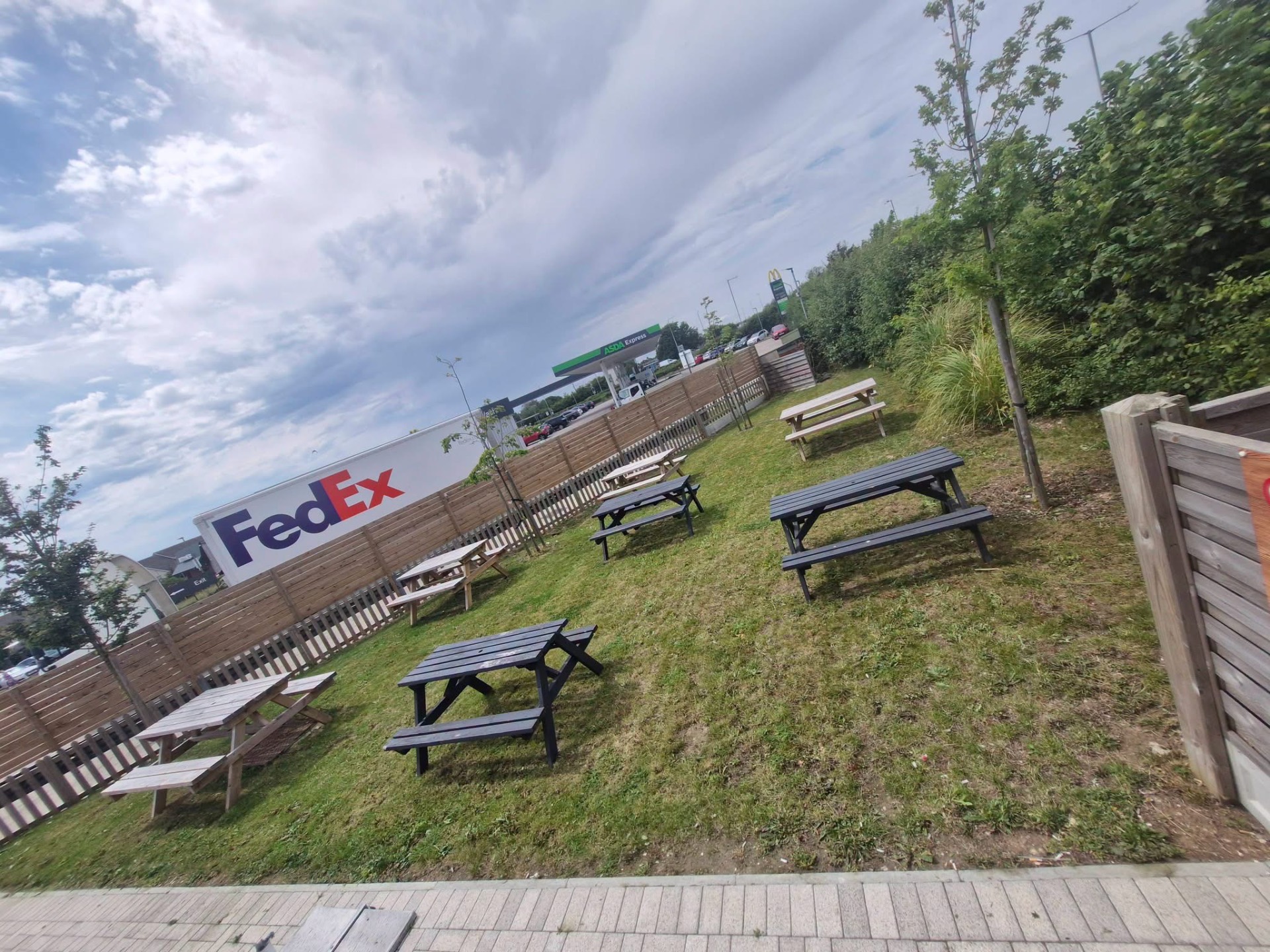Commercial lawn maintained around picnic benches and fencing