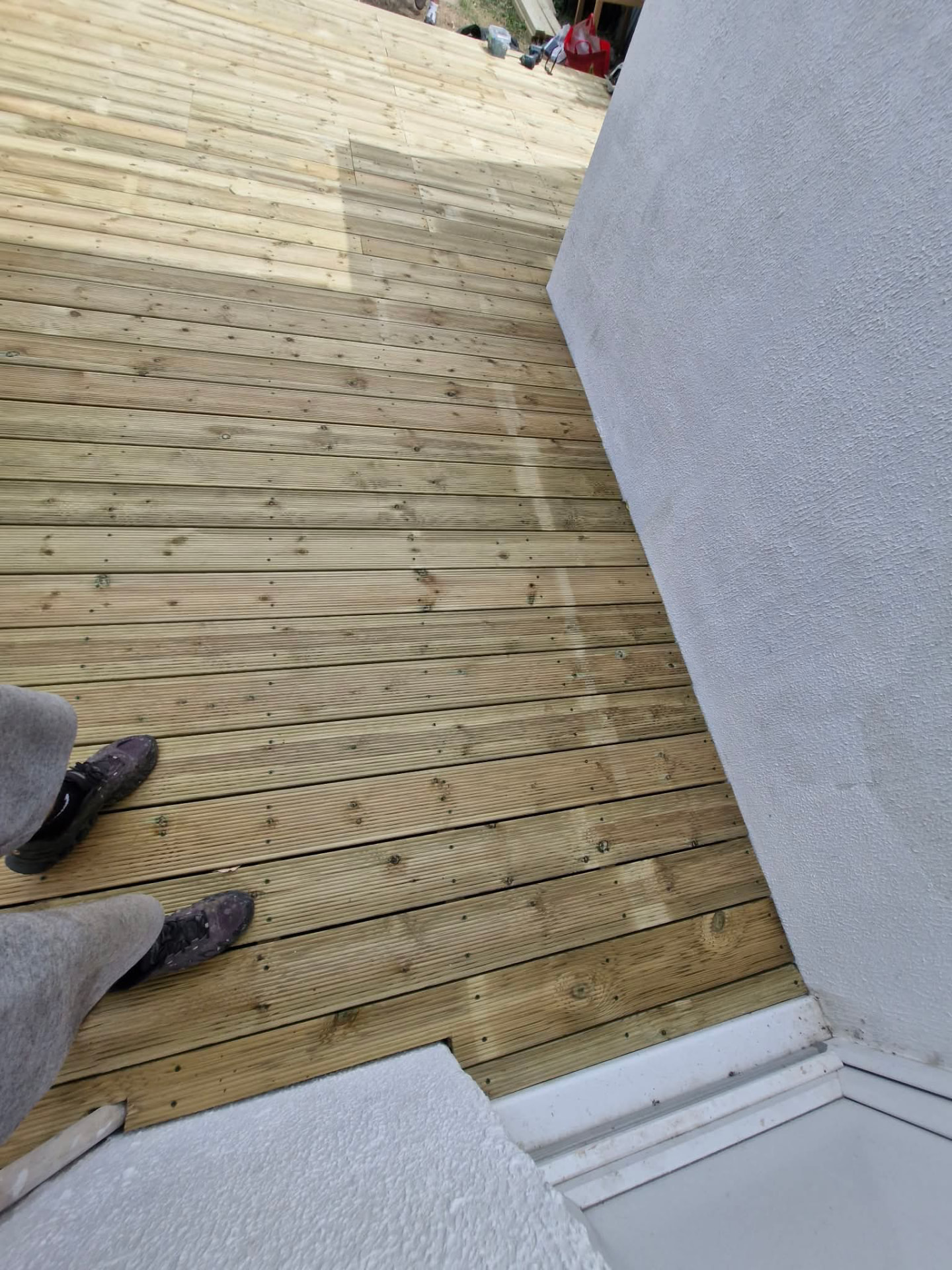 Finished decking scribed neatly around the house wall and doorway