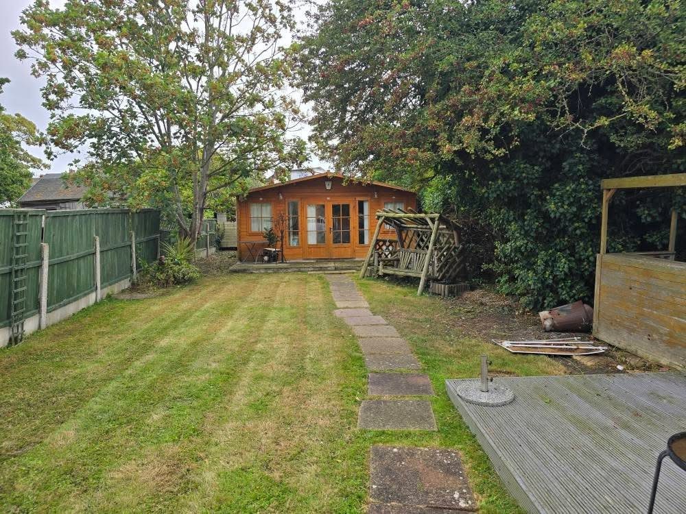 Rear garden mown with stepping-stone path leading to summerhouse