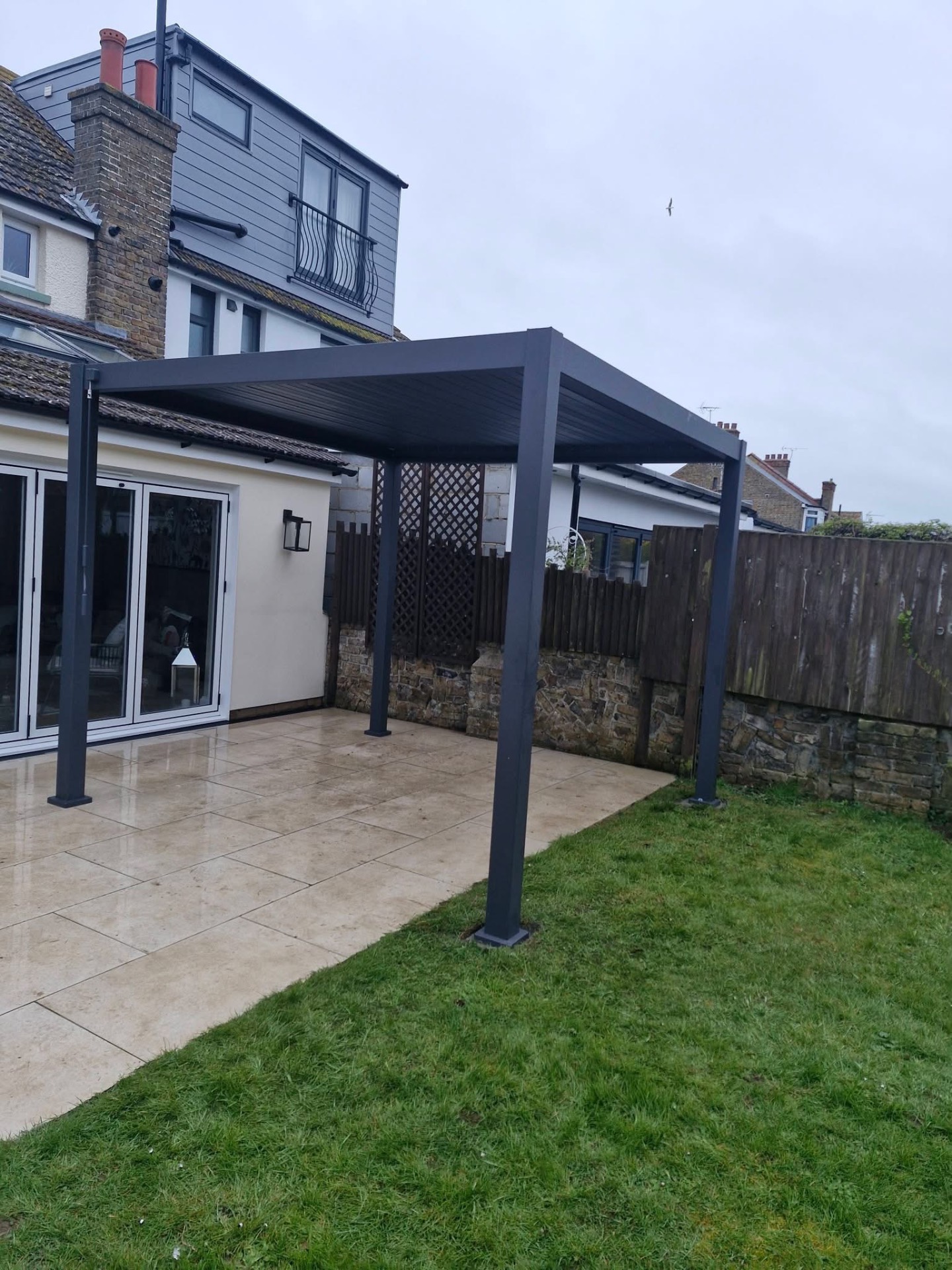Grey aluminium louvred pergola installed on rear patio