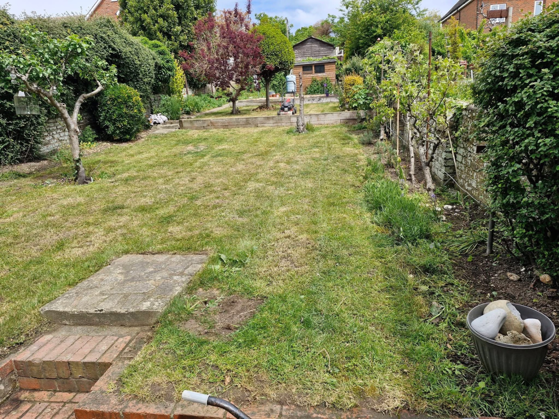 Long walled garden with fruit trees, lawn cut and borders edged