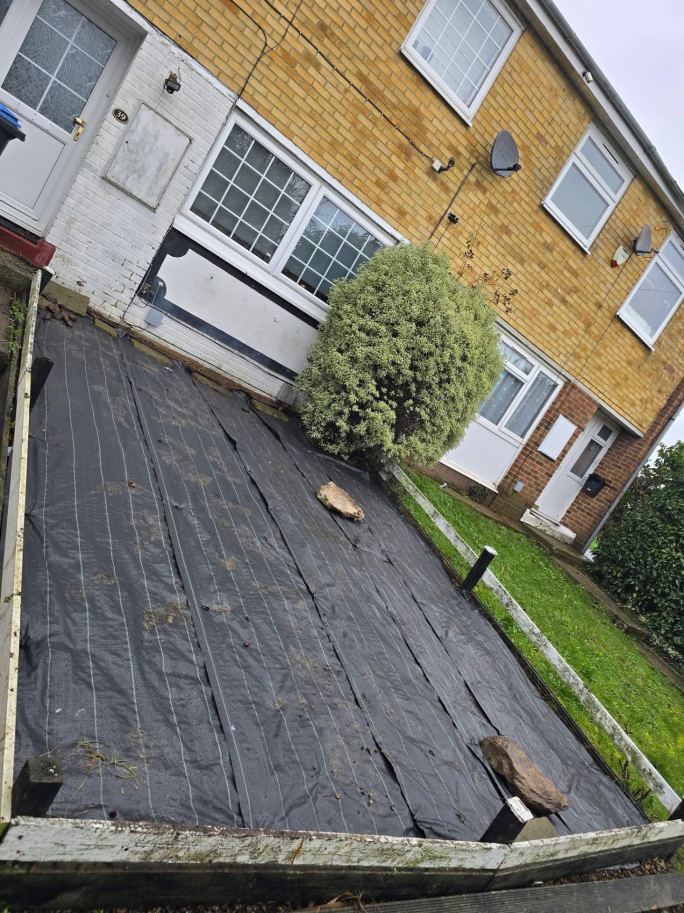 Weed membrane laid over a front garden ready for gravel