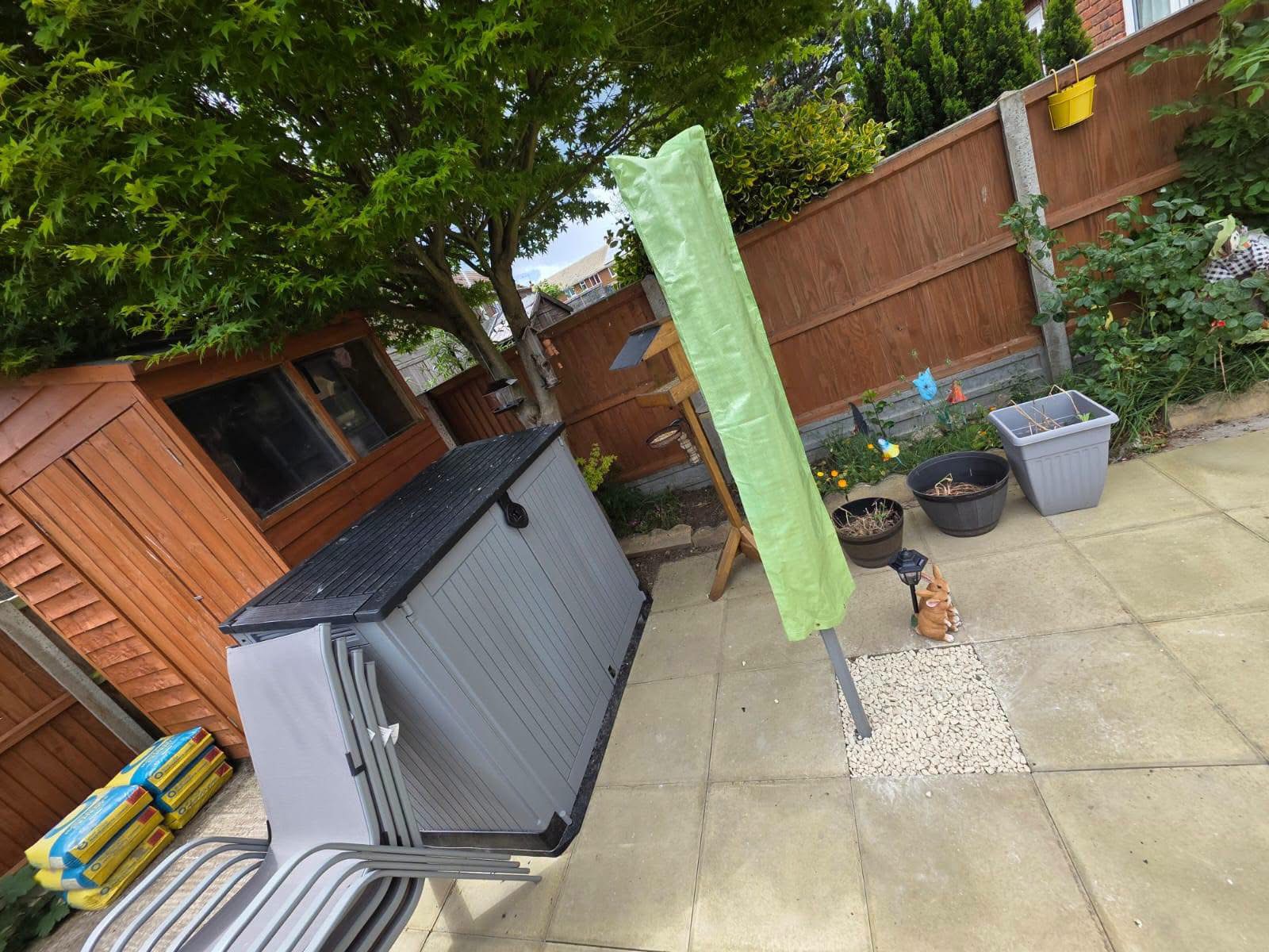 Patio garden with storage box, parasol and Japanese maple tree