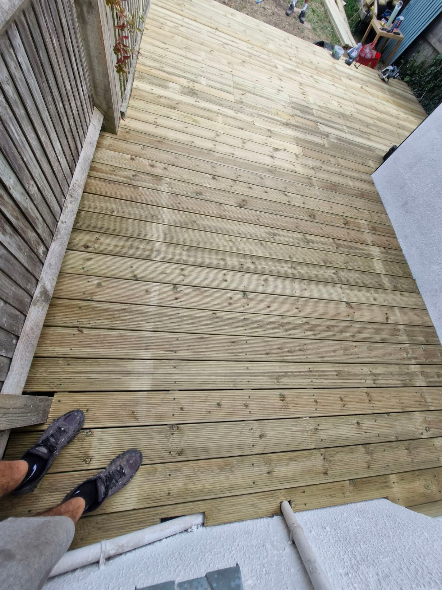 Completed timber deck running the width of the garden beside the fence
