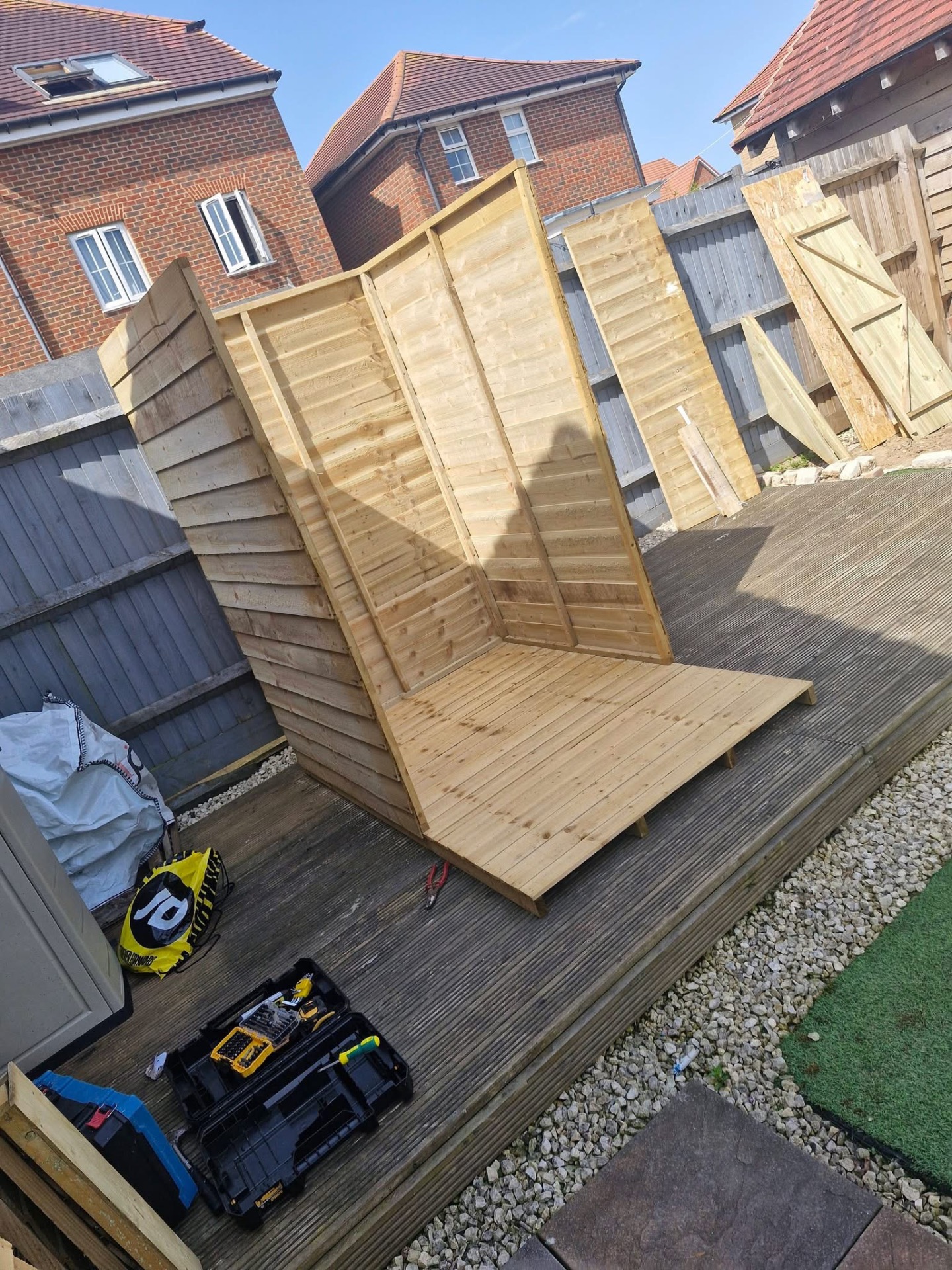 Fresh timber fence panels being fitted along garden boundary